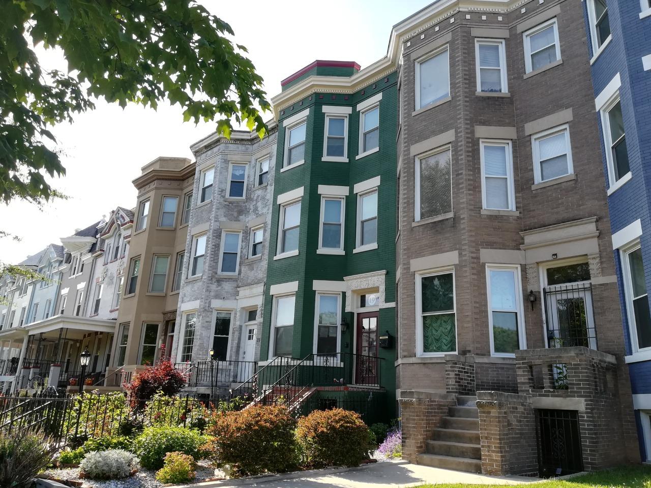A row of townhouses with bay windows on a residential street